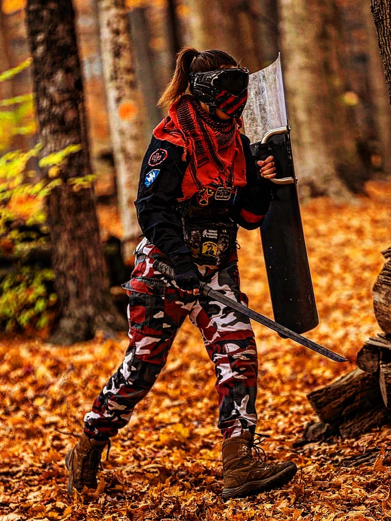 Rebecca Guerin in full paintball kit with a sword and shield